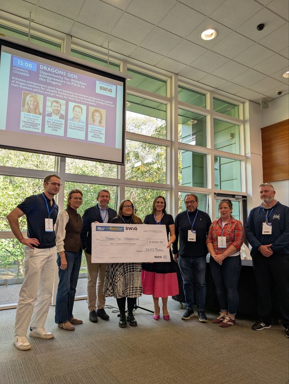Dragons' Den panel and entrepreneurs with a £1,000 cheque from SWIG Finance